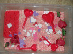 Valentine's theme - pink and white colored rice, heart measuring cups and ice cube tray, felt heart stickers, fake roses