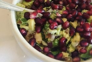 picture of a bowl of guacamole with pomegranate seeds in it