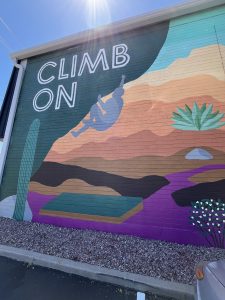 mural depicting phoenix desert and a rock climber that says climb on